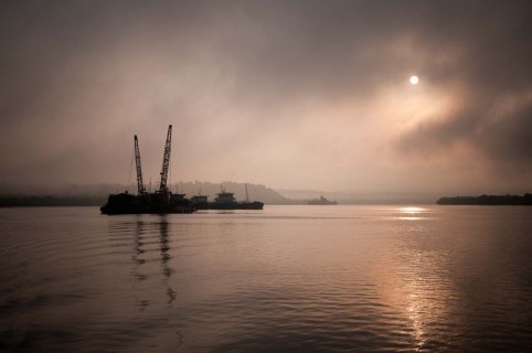 Sand dredgers at dawn on the Tatai river, Cambodia